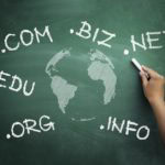 Com, biz, net, edu, org, info - representations of various domain extensions for websites on a chalkboard with a globe illustration, emphasizing web presence and digital marketing.