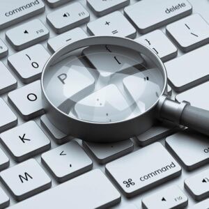 Magnifying glass on computer keyboard emphasizing letter P