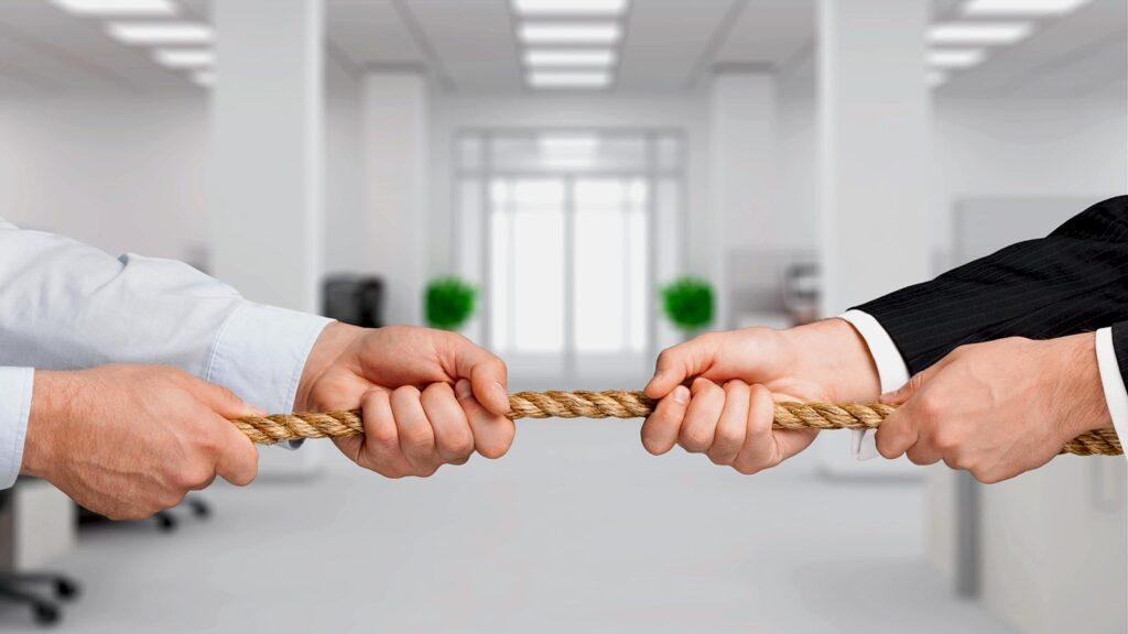 Business people pulling rope in office competition